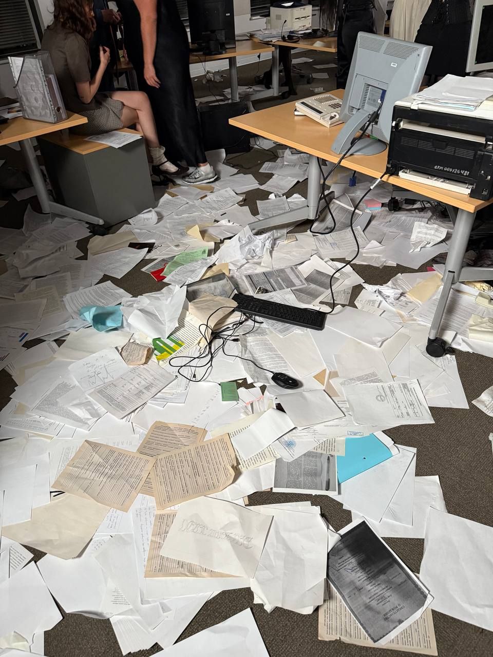 An office floor buried under scattered paperwork